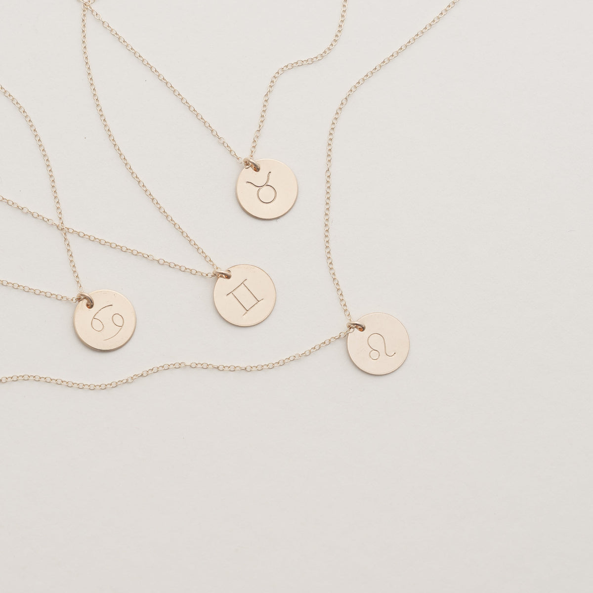 Hand-stamped gold filled zodiac necklaces with astrology symbols