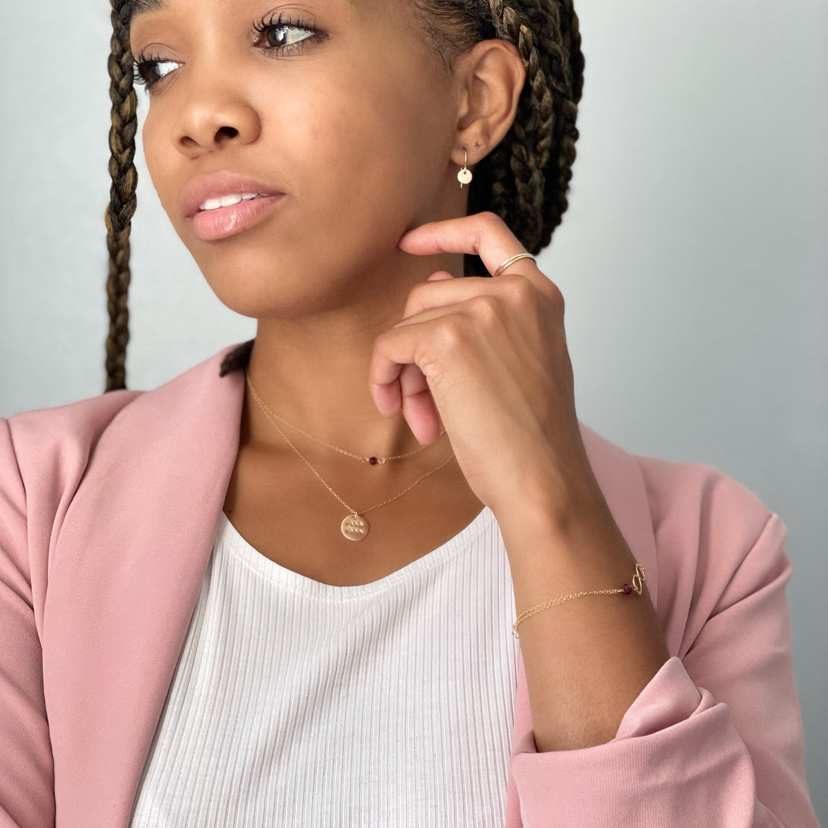 Model wearing layered gold fill necklaces, earrings, rings, and bracelet